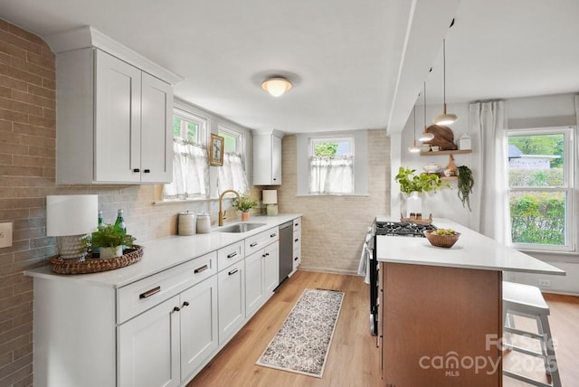 1000 Oakshade Ave, Kannapolis, NC 28083 - kitchen featuring a sink, stainless steel appliances, light countertops, a kitchen bar, and brick wall
