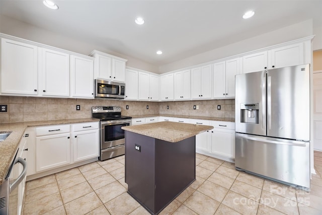 kitchen featuring appliances with stainless steel finishes, white cabinets, light stone countertops, tasteful backsplash, and recessed lighting