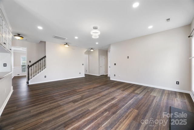 spare room featuring dark wood finished floors, stairs, baseboards, and recessed lighting