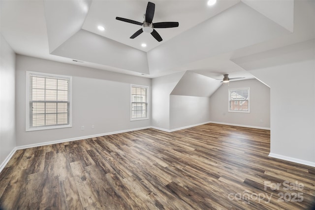 additional living space featuring a ceiling fan, dark wood-type flooring, baseboards, lofted ceiling, and recessed lighting