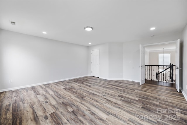 unfurnished room with wood finished floors, recessed lighting, and baseboards