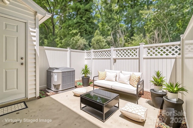 view of patio / terrace with cooling unit, an outdoor living space, a fenced backyard, and view of scattered trees