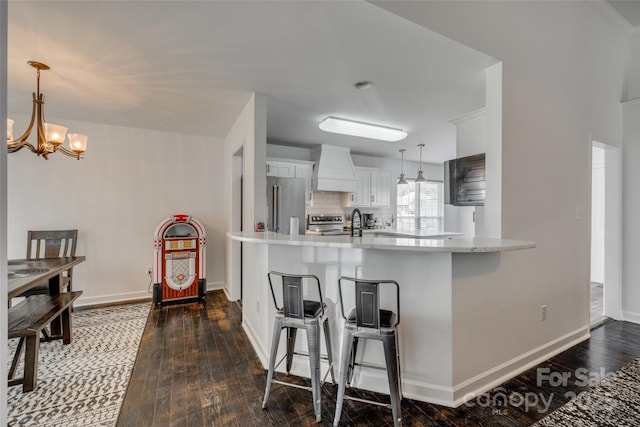 1140 Landsdown Dr, Salisbury, NC 28147 - kitchen with appliances with stainless steel finishes, premium range hood, light countertops, dark wood-type flooring, and a chandelier