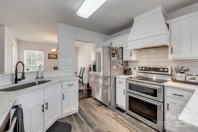 1140 Landsdown Dr, Salisbury, NC 28147 - kitchen with appliances with stainless steel finishes, premium range hood, a sink, decorative backsplash, and white cabinetry