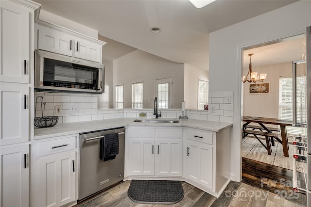 1140 Landsdown Dr, Salisbury, NC 28147 - kitchen with stainless steel appliances, a sink, tasteful backsplash, a chandelier, and white cabinetry