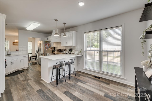 1140 Landsdown Dr, Salisbury, NC 28147 - kitchen with a peninsula, appliances with stainless steel finishes, a sink, backsplash, and white cabinetry