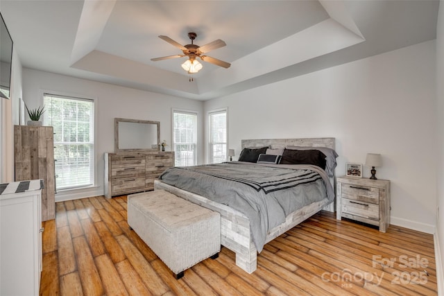 1140 Landsdown Dr, Salisbury, NC 28147 - bedroom with a tray ceiling, light wood finished floors, ceiling fan, and baseboards