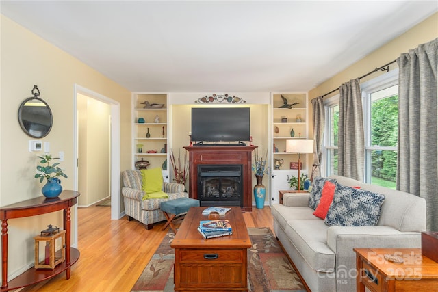 307 Tree Haven Blvd, Hendersonville, NC 28791 - living room featuring a glass covered fireplace, light wood-type flooring, and built in features