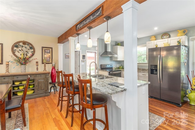 307 Tree Haven Blvd, Hendersonville, NC 28791 - kitchen with stainless steel appliances, a sink, wall chimney range hood, decorative columns, and healthy amount of natural light