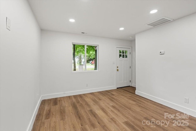 empty room featuring baseboards, wood finished floors, and recessed lighting