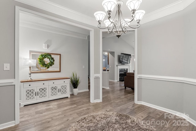 3820 Leela Palace Way, Fort Mill, SC 29708 - dining area with wood finished floors, a chandelier, crown molding, a glass covered fireplace, and baseboards