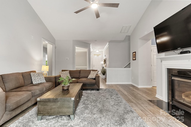 3820 Leela Palace Way, Fort Mill, SC 29708 - living room with lofted ceiling, wood finished floors, ceiling fan, a fireplace with flush hearth, and baseboards