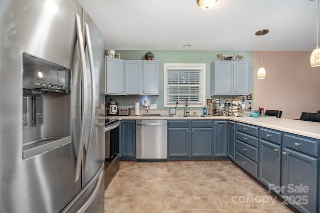 1221 Woodpecker Dr, Clover, SC 29710 - kitchen featuring stainless steel appliances, a sink, light countertops, a peninsula, and pendant lighting