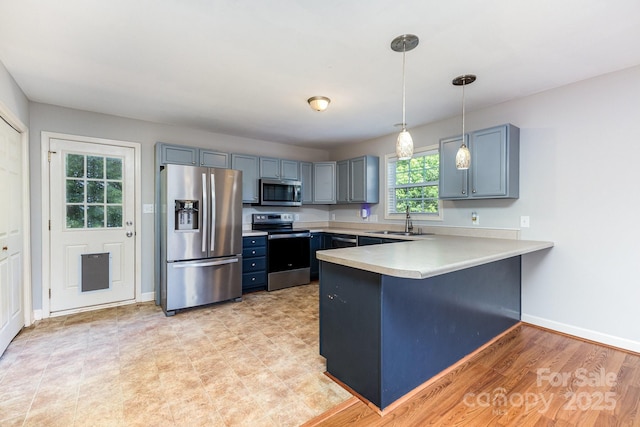 1221 Woodpecker Dr, Clover, SC 29710 - kitchen featuring stainless steel appliances, a peninsula, light countertops, decorative light fixtures, and a kitchen breakfast bar
