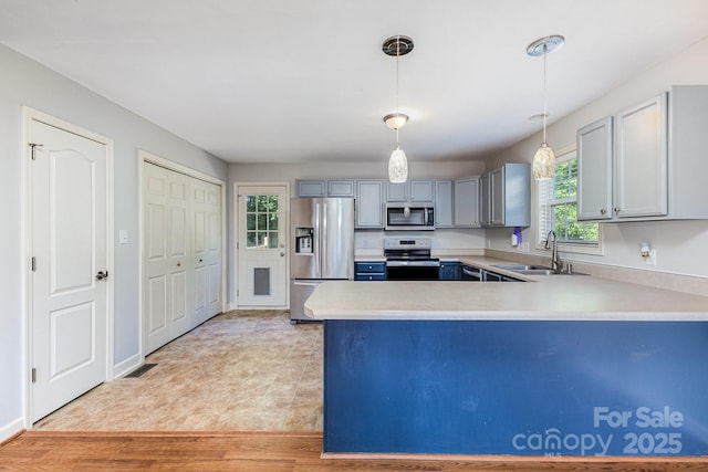 1221 Woodpecker Dr, Clover, SC 29710 - kitchen featuring stainless steel appliances, light countertops, a peninsula, and pendant lighting