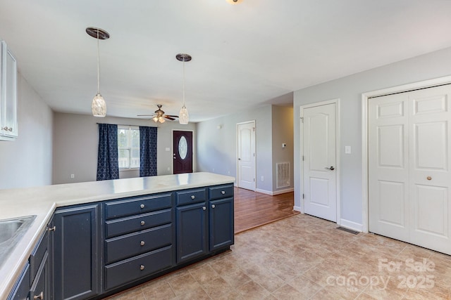 1221 Woodpecker Dr, Clover, SC 29710 - kitchen featuring blue cabinetry, a ceiling fan, pendant lighting, light countertops, and a peninsula