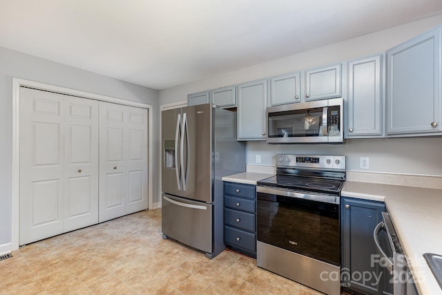 1221 Woodpecker Dr, Clover, SC 29710 - kitchen featuring appliances with stainless steel finishes, light countertops, and blue cabinets