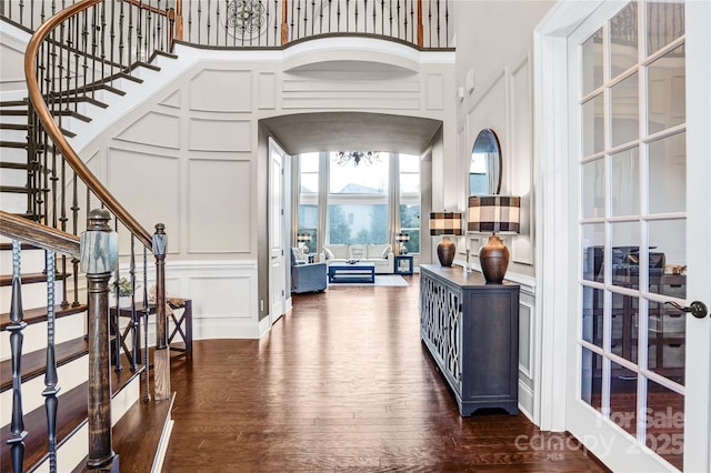 13204 Feale Ct, Charlotte, NC 28278 - entryway with a decorative wall, a towering ceiling, dark wood-style floors, stairs, and arched walkways