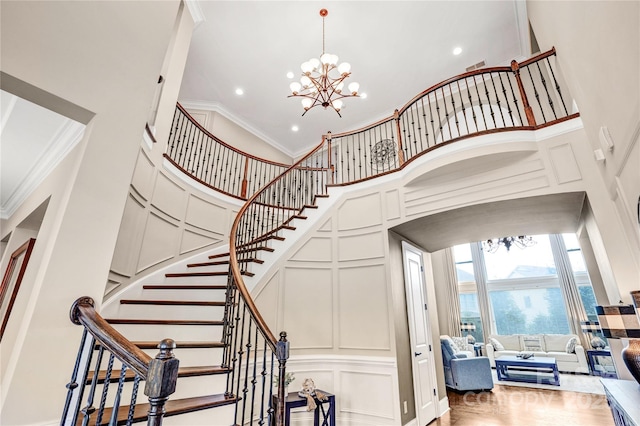 13204 Feale Ct, Charlotte, NC 28278 - stairway featuring a decorative wall, a high ceiling, ornamental molding, a chandelier, and recessed lighting