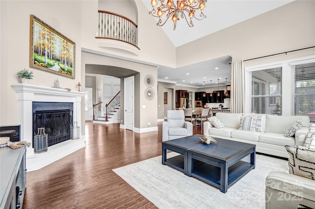 13204 Feale Ct, Charlotte, NC 28278 - living room with wood finished floors, a chandelier, baseboards, a glass covered fireplace, and arched walkways