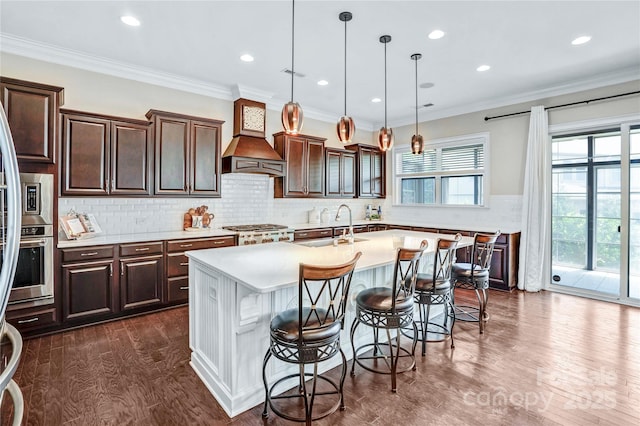 13204 Feale Ct, Charlotte, NC 28278 - kitchen featuring an island with sink, light countertops, dark wood-style floors, a kitchen bar, and dark brown cabinetry