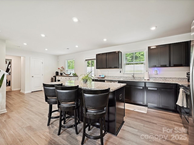 kitchen featuring a kitchen bar, plenty of natural light, a kitchen island, electric stove, and recessed lighting