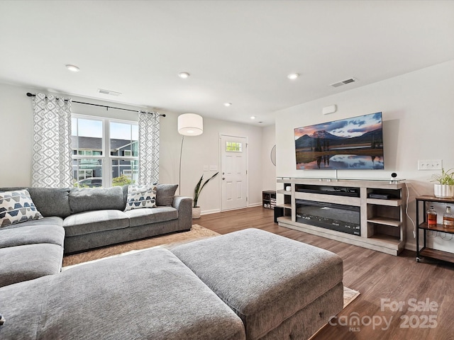 living room featuring wood finished floors, baseboards, and recessed lighting