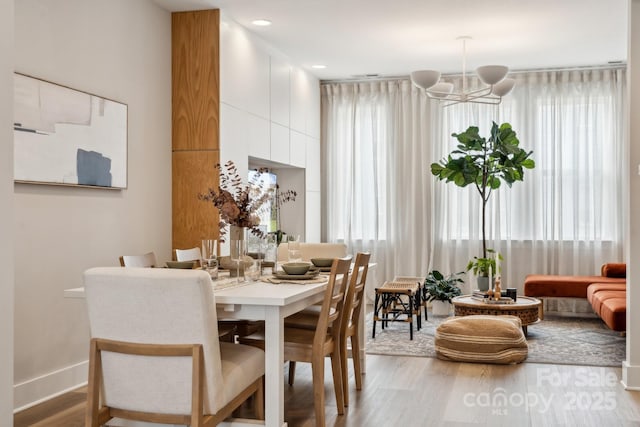 dining room with wood finished floors, a chandelier, and healthy amount of natural light