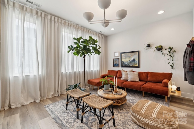 living area featuring light wood-type flooring, a chandelier, and recessed lighting