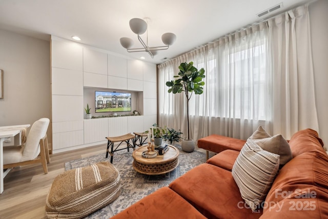 living area featuring light wood-type flooring, a chandelier, and recessed lighting
