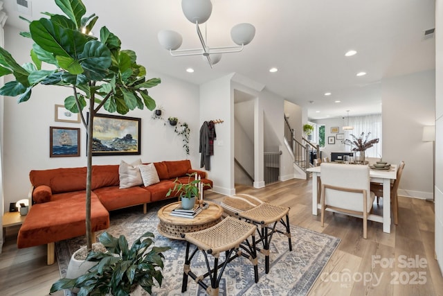 living room with a chandelier, stairs, light wood-type flooring, recessed lighting, and baseboards