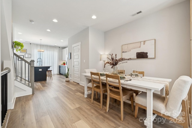 dining area with stairs, light wood-type flooring, recessed lighting, and baseboards