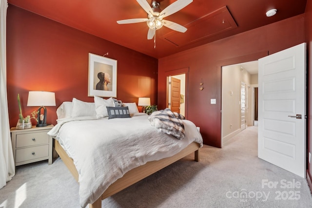 bedroom featuring attic access, light colored carpet, a ceiling fan, and baseboards