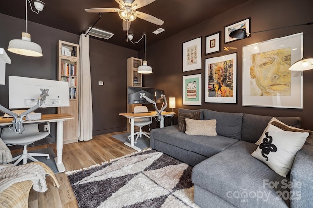 living room featuring wood finished floors, ceiling fan, and an office area