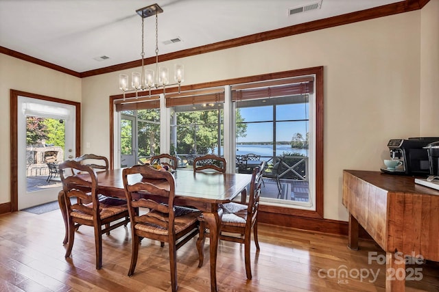 2102 Lake Rd, Ridgeway, SC 29130 - dining space with light wood-style flooring, ornamental molding, baseboards, and a water view