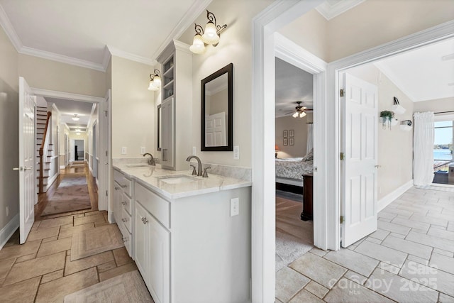 2102 Lake Rd, Ridgeway, SC 29130 - ensuite bathroom featuring double vanity, stone tile floors, ceiling fan, crown molding, and baseboards