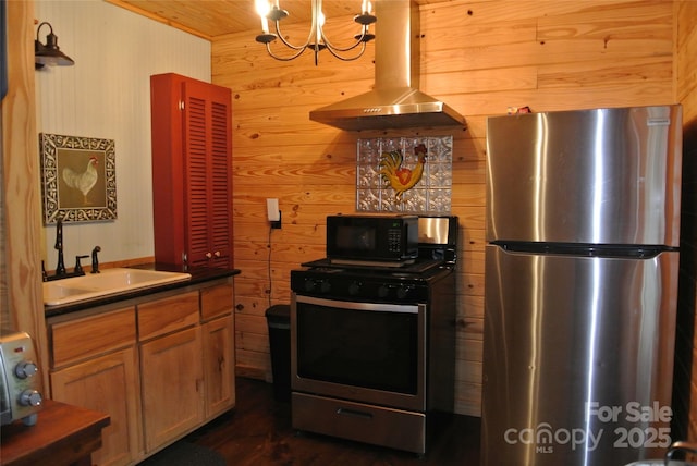 kitchen featuring stainless steel appliances, ventilation hood, wooden ceiling, wooden walls, and a sink