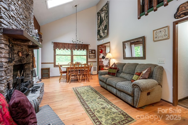 5 Creekside Dr, Maggie Valley, NC 28751 - living room featuring high vaulted ceiling, wood finished floors, a fireplace, and a chandelier