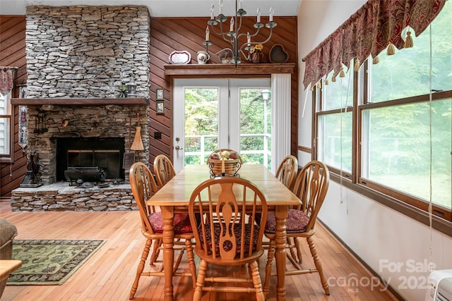 5 Creekside Dr, Maggie Valley, NC 28751 - dining area featuring hardwood / wood-style floors, wooden walls, a fireplace, a towering ceiling, and a chandelier