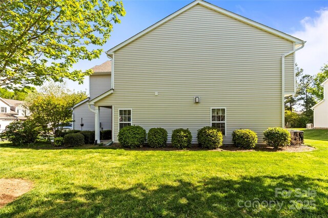 back of house featuring a lawn