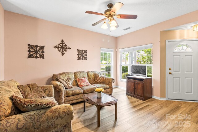 living area featuring light wood finished floors, ceiling fan, and baseboards