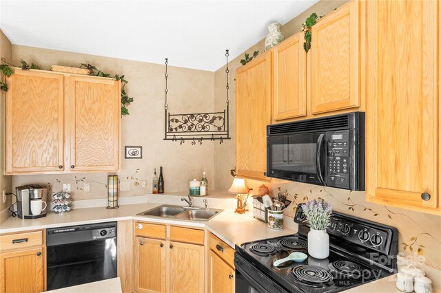 kitchen with black appliances, a sink, light brown cabinetry, light countertops, and backsplash