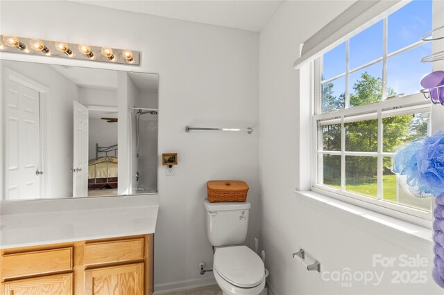 ensuite bathroom with plenty of natural light, toilet, vanity, and a shower