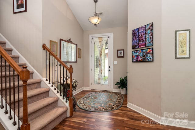entrance foyer featuring wood finished floors, stairs, baseboards, and vaulted ceiling