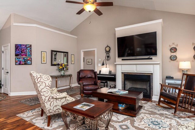 living area featuring a ceiling fan, wood finished floors, a fireplace, baseboards, and high vaulted ceiling