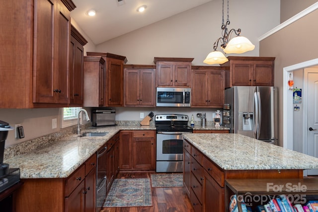 kitchen featuring appliances with stainless steel finishes, a sink, dark wood-style floors, light stone counters, and hanging light fixtures