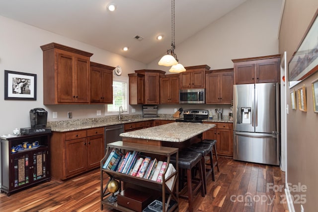 kitchen with appliances with stainless steel finishes, a sink, dark wood-style floors, high vaulted ceiling, and a center island
