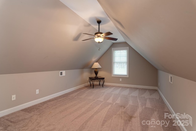 additional living space with ceiling fan, lofted ceiling, carpet flooring, and baseboards