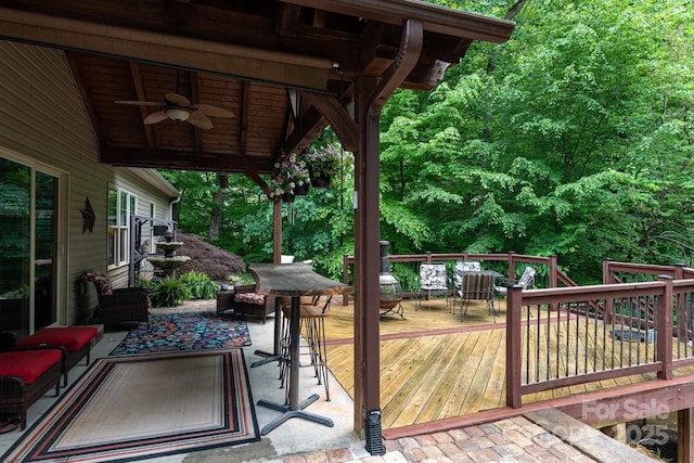 wooden terrace featuring ceiling fan, outdoor dining space, and an outdoor hangout area