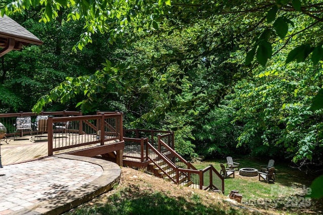 view of yard with a fire pit, a wooden deck, and stairs